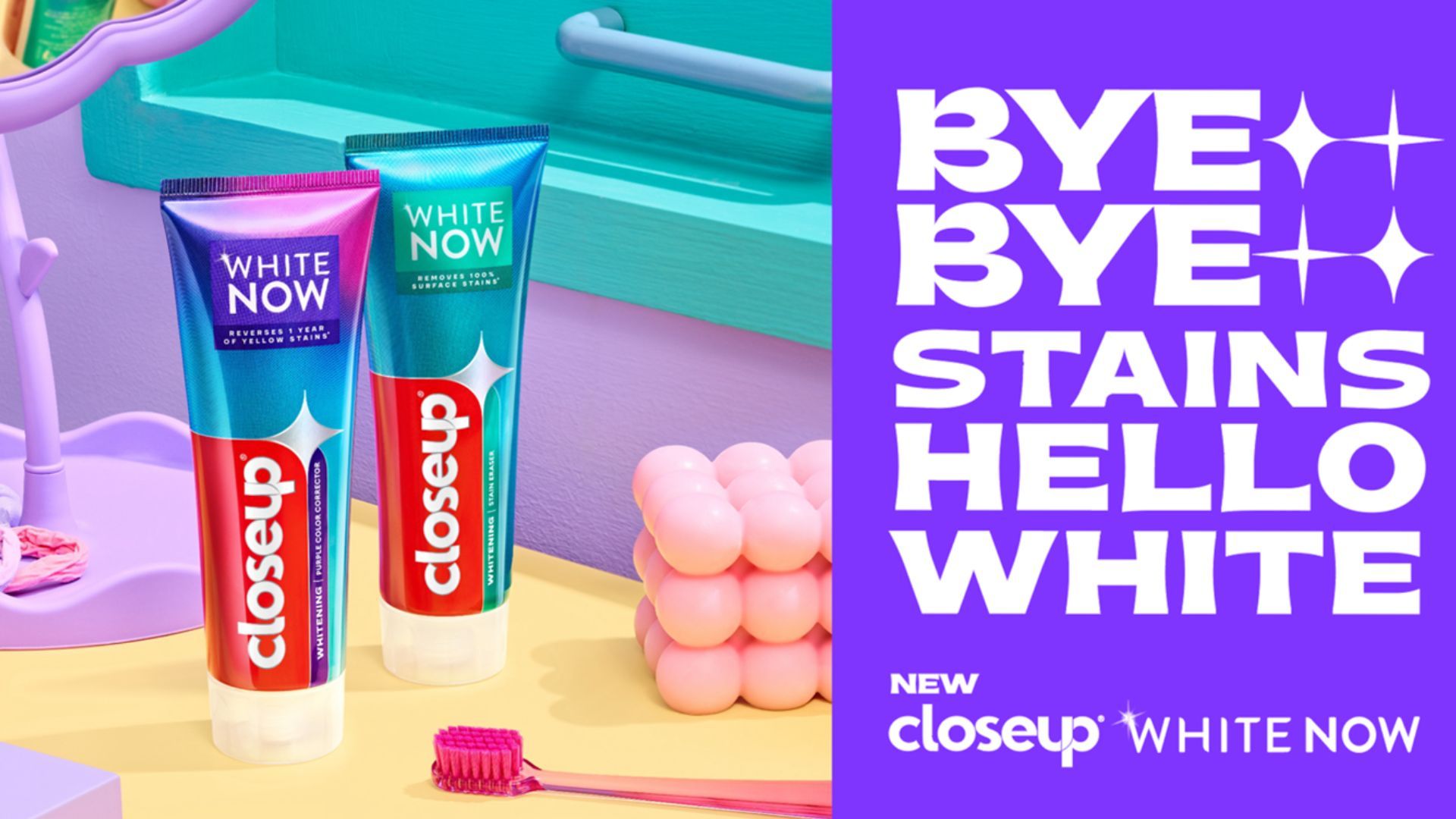 Two tubes of Closeup White Now toothpaste are displayed on a pastel-coloured surface next to a pink toothbrush. The headline reads: 'Bye Bye Stains, Hello White' in white text on a bright purple background.