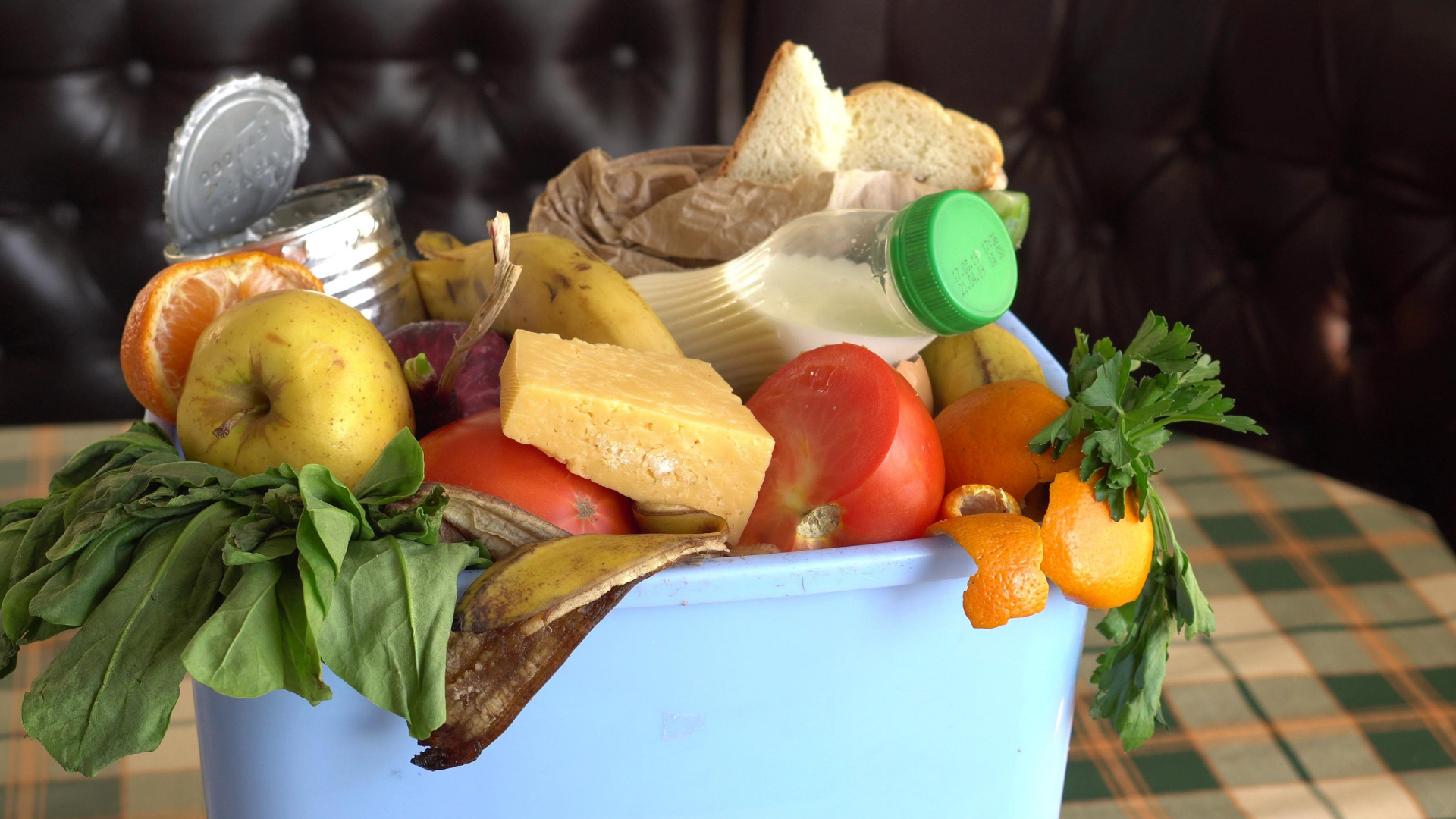 Assorted food waste in a blue bin.