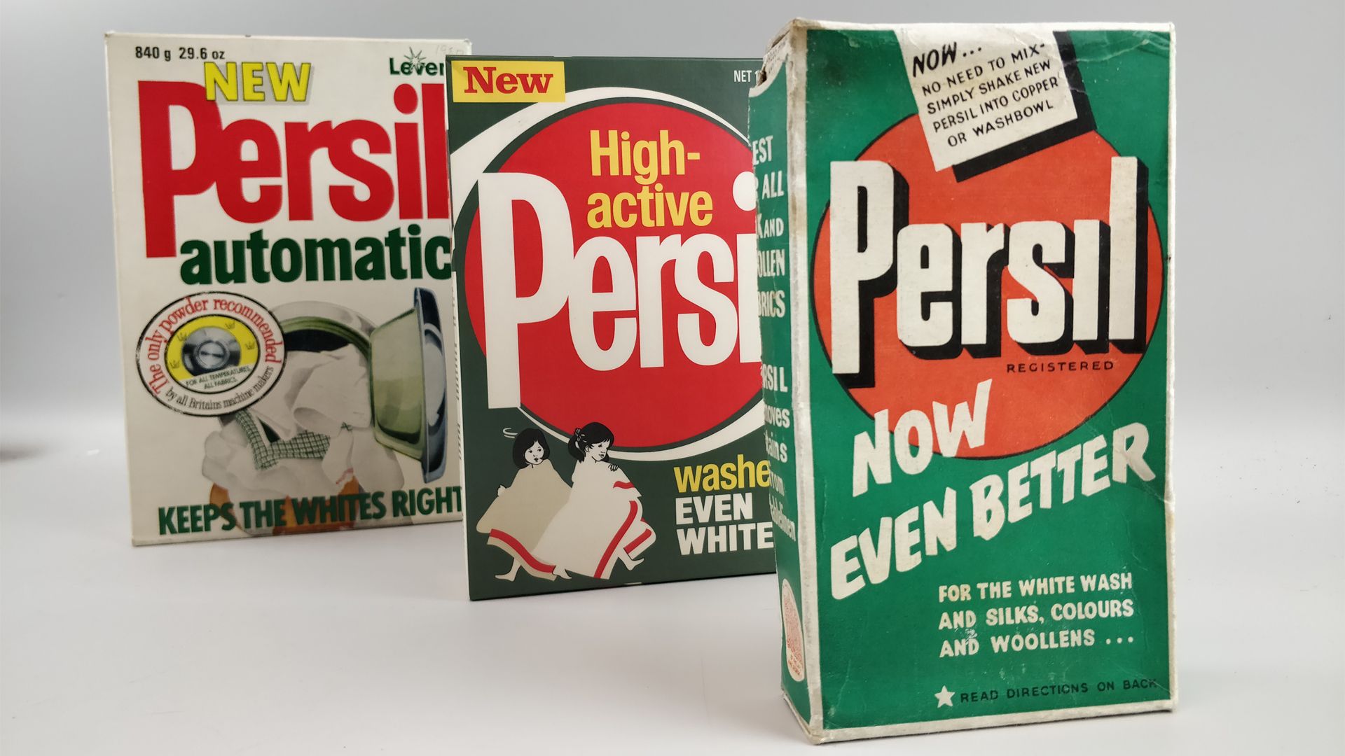 Vintage illustration of two children dressed in red and yellow woollen suits sitting on a log, playing.