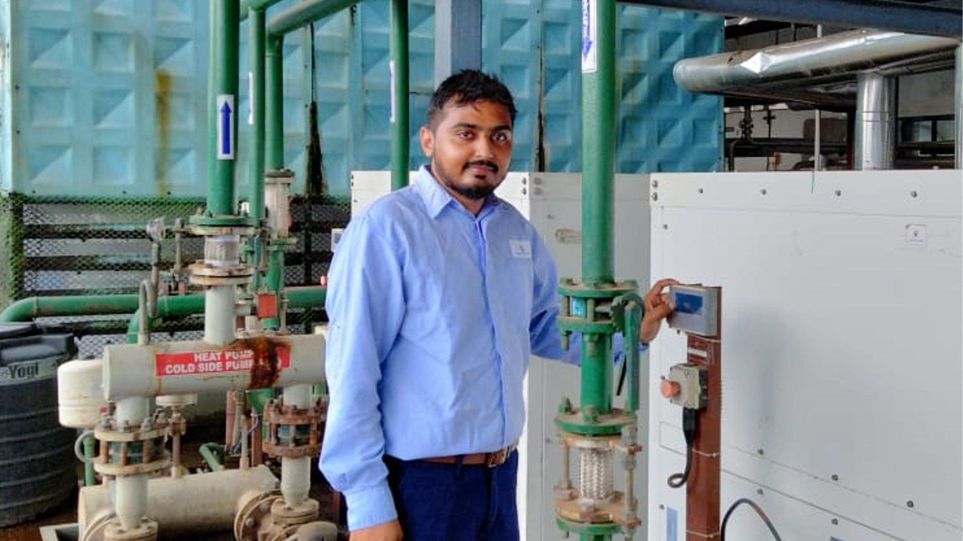 Kothiya Jaydeep from Unilever Hindustan beside a heat pump used to heat water, eliminating the need for diesel
