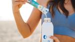 Woman pouring powdered Liquid I.V. electrolyte drink mix from a sachet into a bottle.
