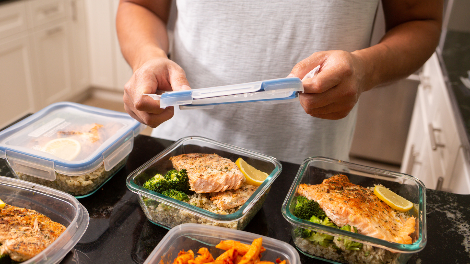 A person putting meals into containers.
