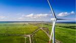 Image of wind turbines turning and generating electricity in a green field