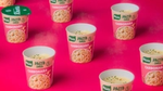 Six Knorr Carbonara Mini Meal pots set against a bright pink background.