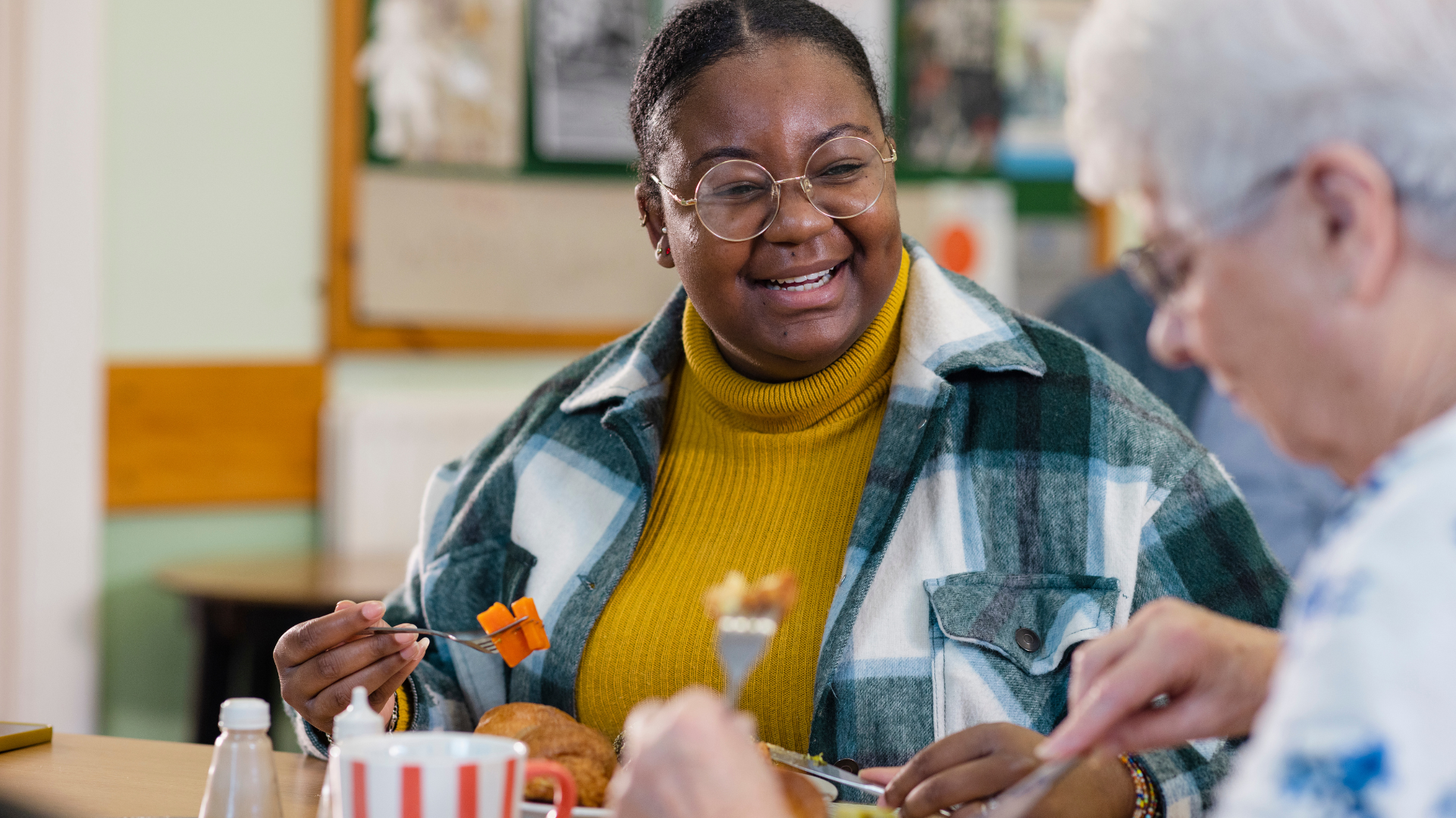 Two people enjoying a meal and smiling at each other.
