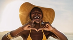 Woman making a heart sign with their hands and smiling