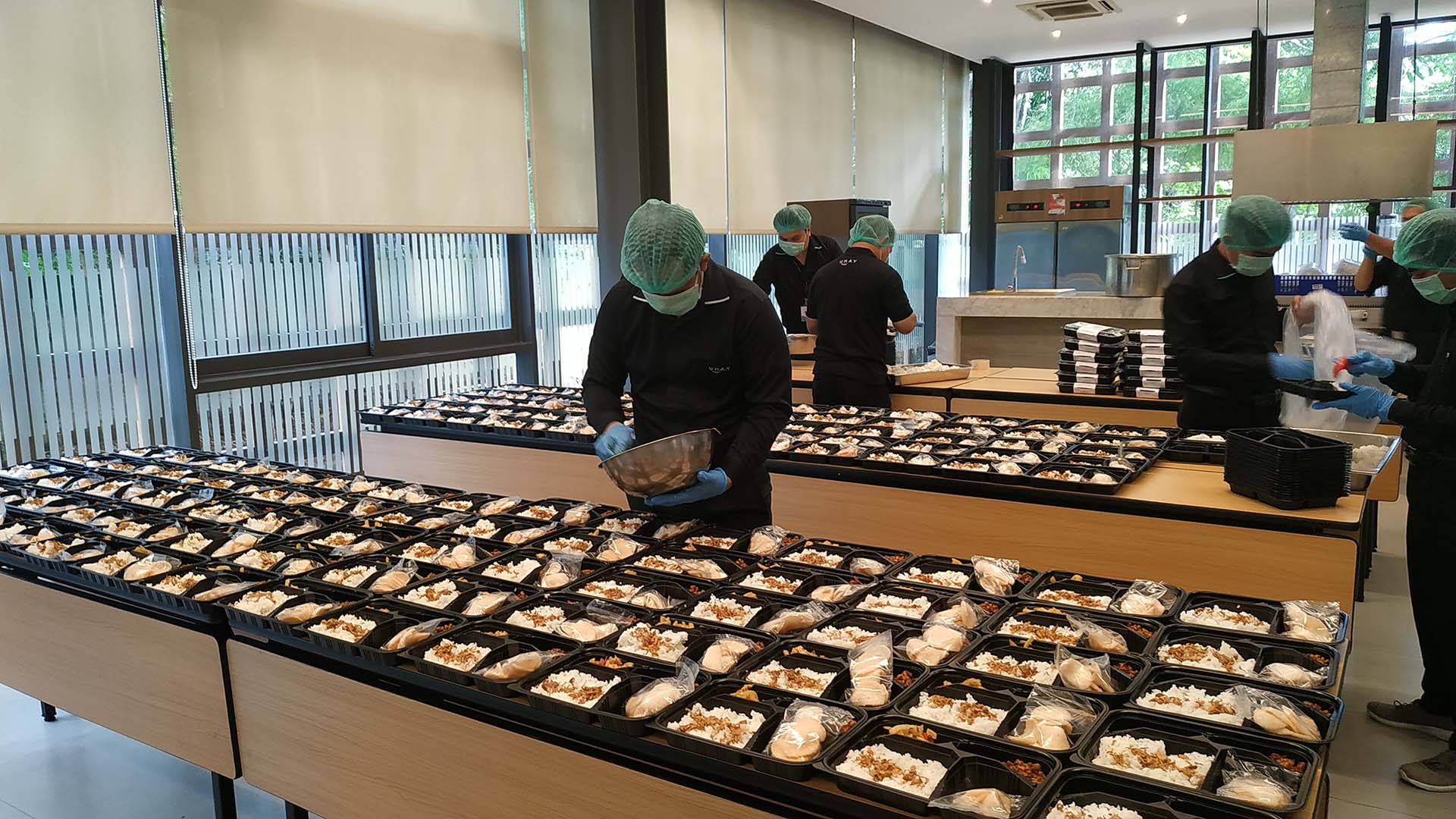 Meal4Meal programme: large tables with donated meals being packed