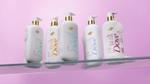 Shelf with five bottles of Dove’s new Serum Shower Collection of body washes, each designed to deliver skincare benefits